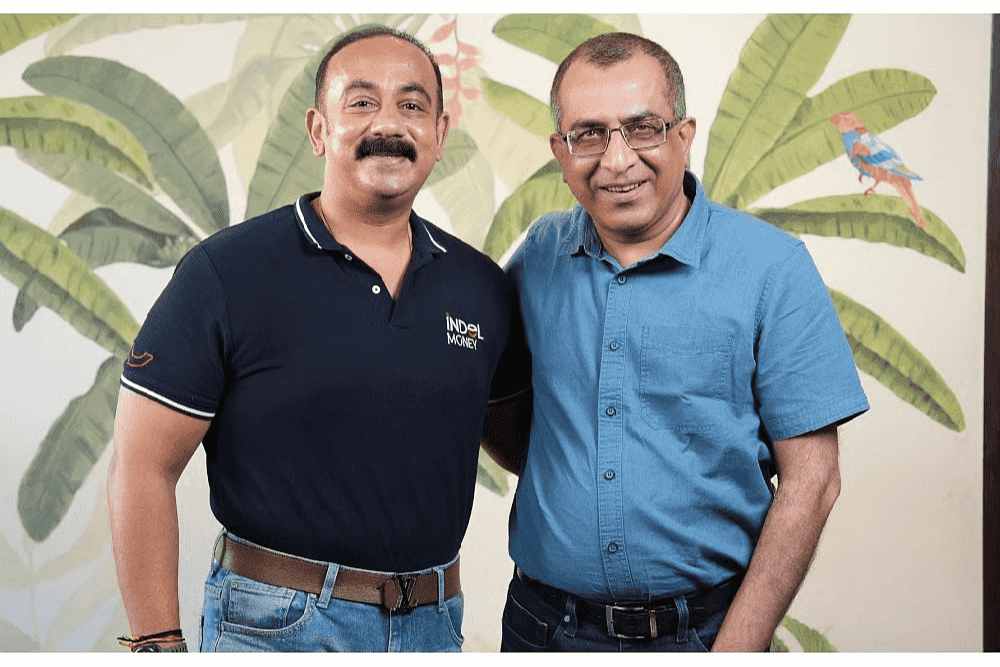 Two business professionals standing together during a discussion on India’s growing reliance on gold as a financial asset, highlighting expert insights on the importance of gold in the Indian economy.