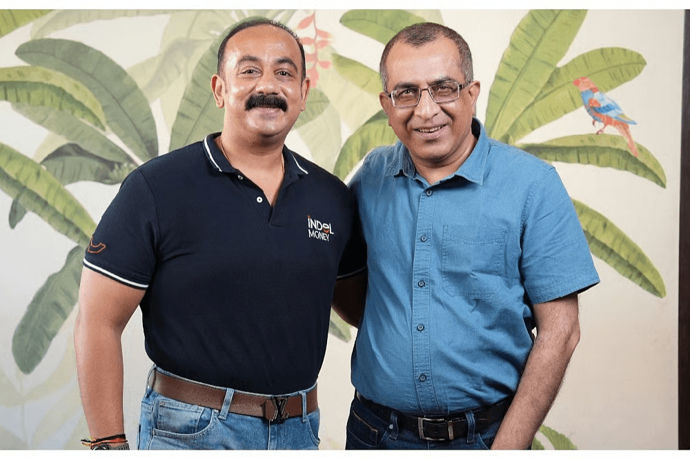 Two business professionals standing together during a discussion on India’s growing reliance on gold as a financial asset, highlighting expert insights on the importance of gold in the Indian economy.